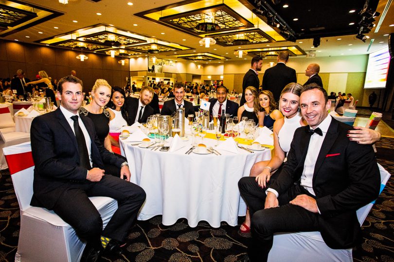 Men and women around a table at a ball