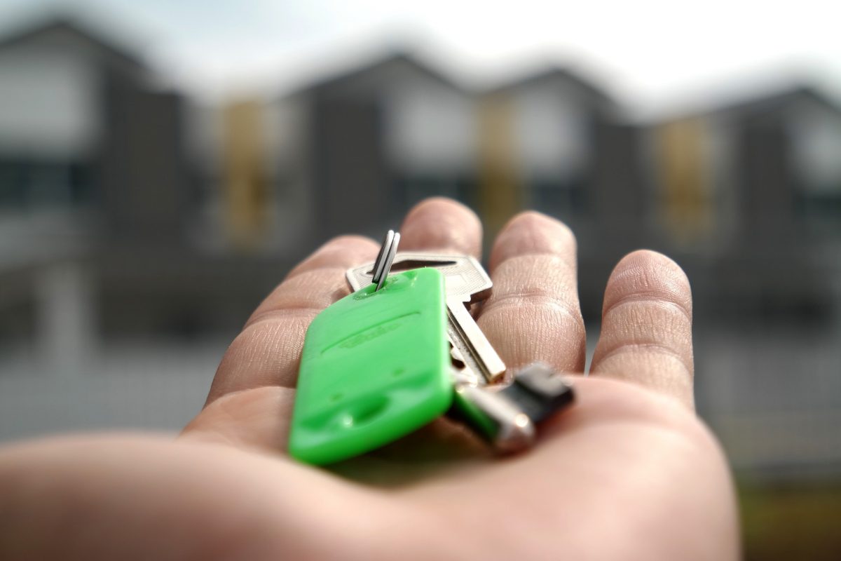 A hand holds out a set of keys