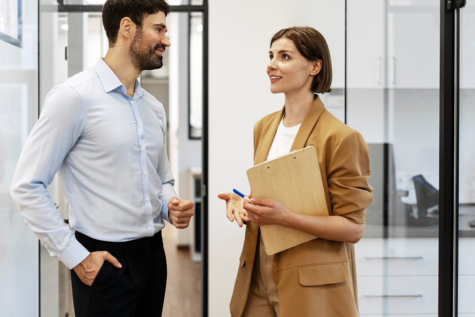 Two businesspeople discussing during a meeting in the office corridor