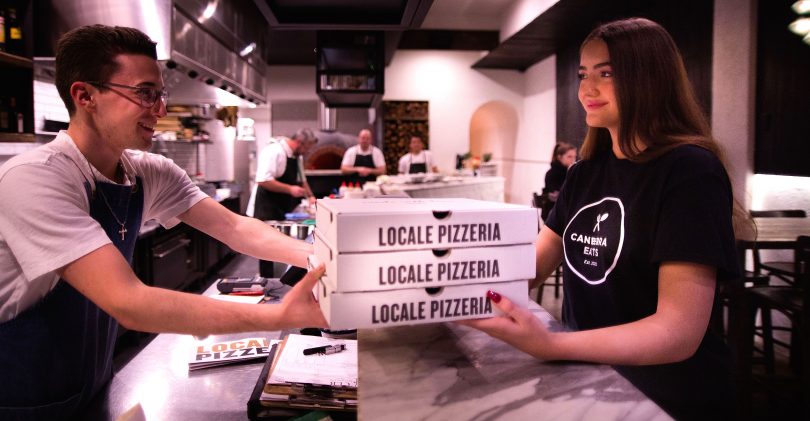 A Canberra Eats delivery driver picks up a pizza order