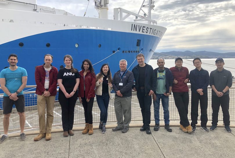 Team of researchers in front of RV Investigator ship at Hobart