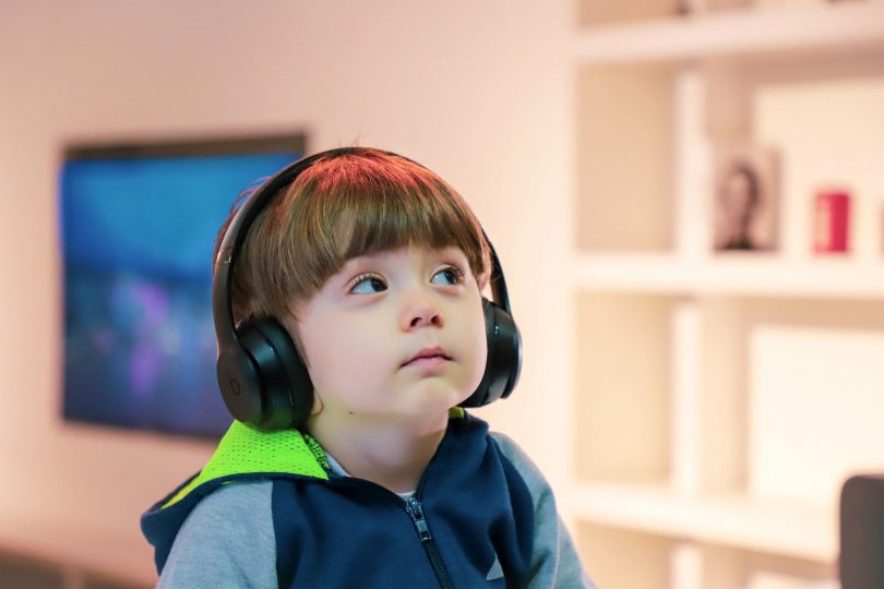 Child with headphones listening to music.
