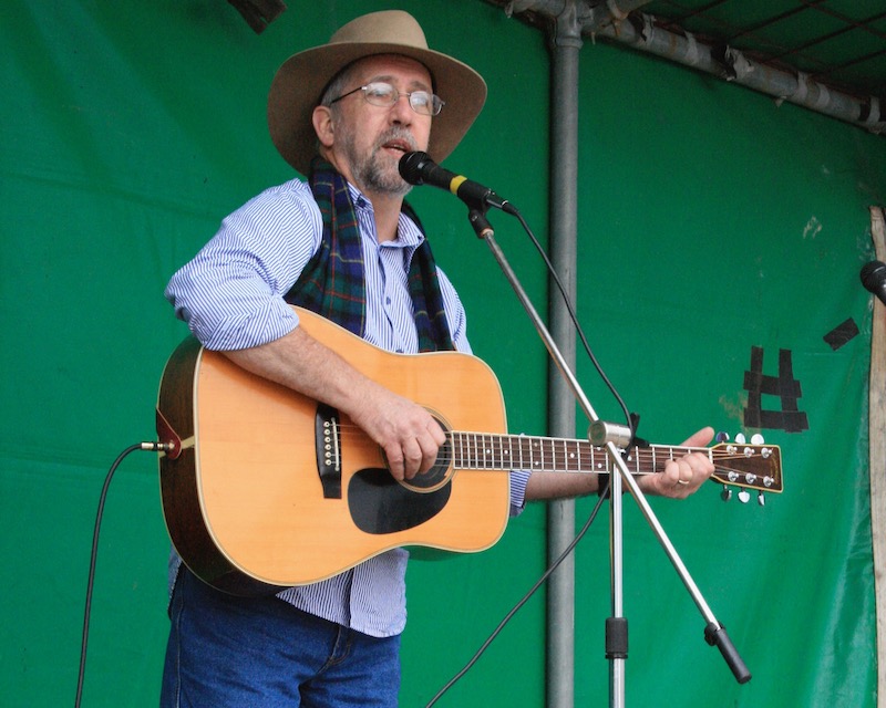 Ron McLaughlin performing with guitar onstage.