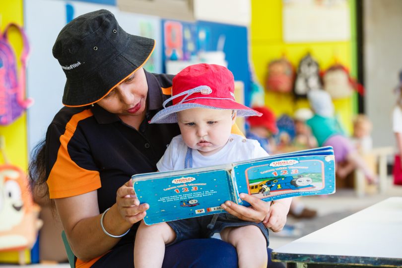 Communities@Work educator reading book to child