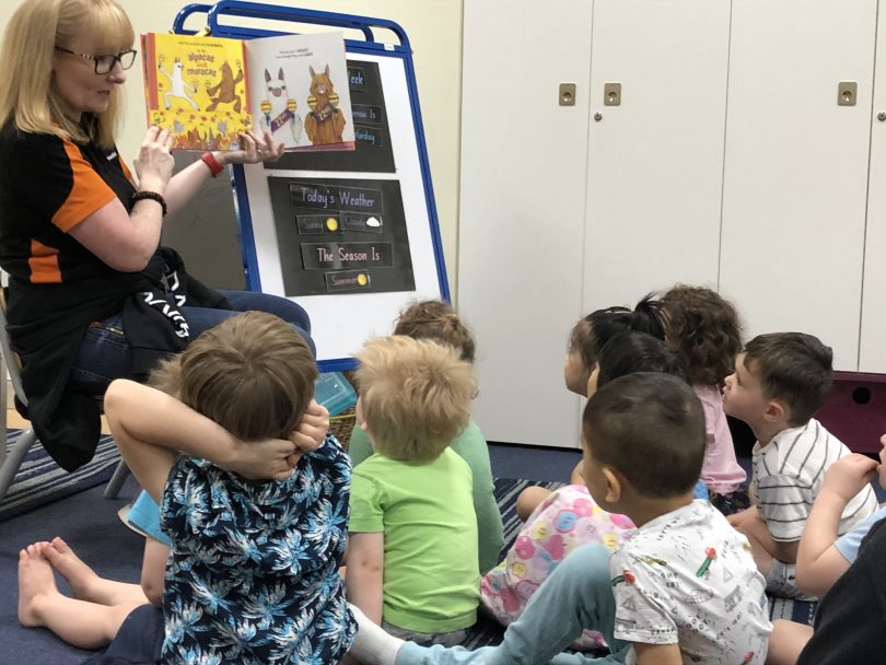 Communities@Work educator reading book to children