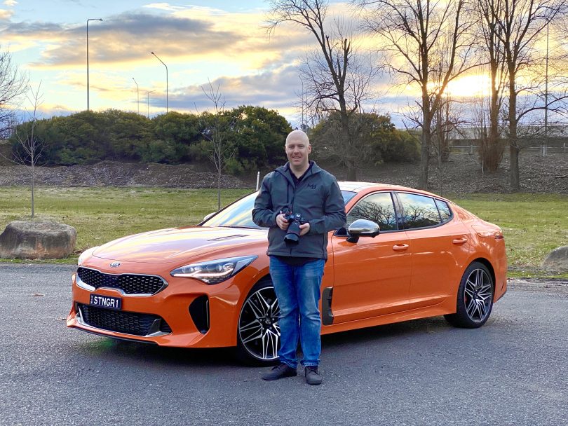 Michael Briguglio standing in front of orange 2021 Kia Stinger GT car