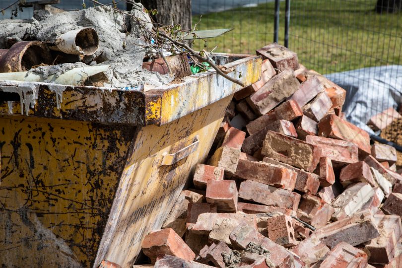 Piles of bricks and cement in skip bins