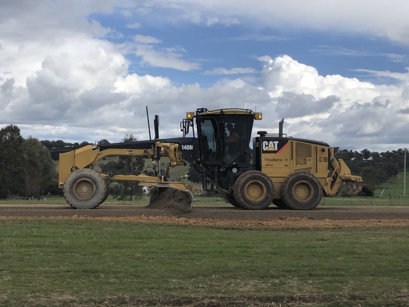 Heavy machinery levelling road at Yarrah