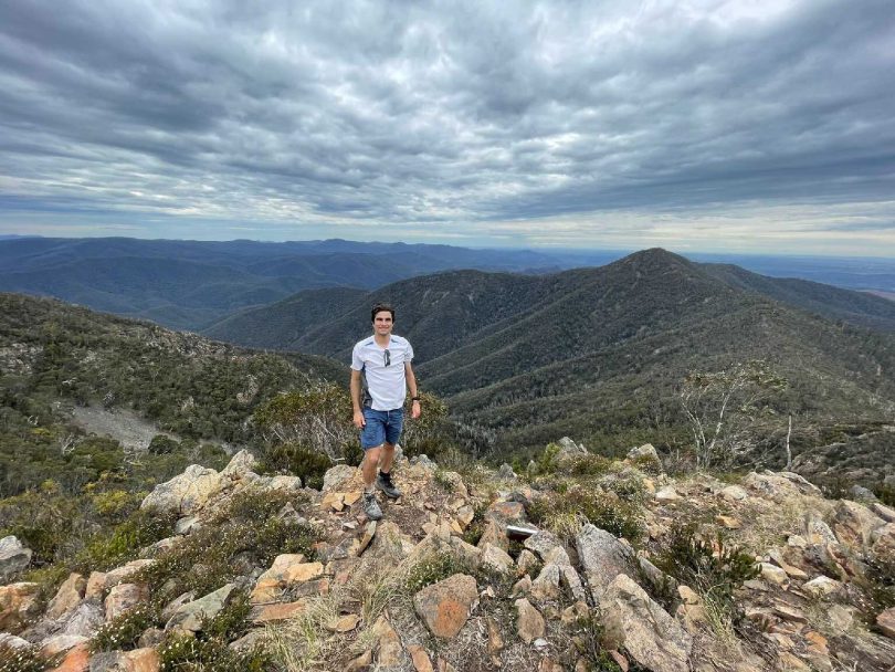 Alex Kalyvas standing atop mountain
