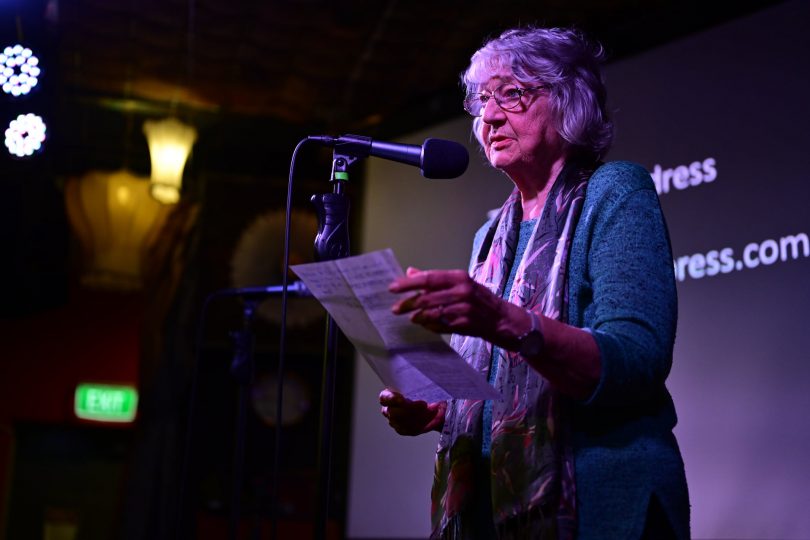 Woman reciting poetry onstage at Smith's Alternative