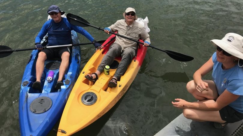 three people on kayaks in the lake on clean up day last year