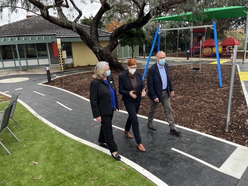 Three people walking near play equipment