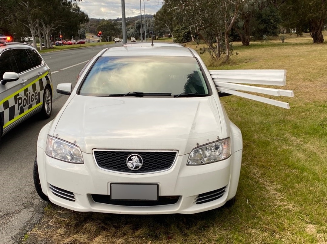 Long panels protrude from a car's passenger window.