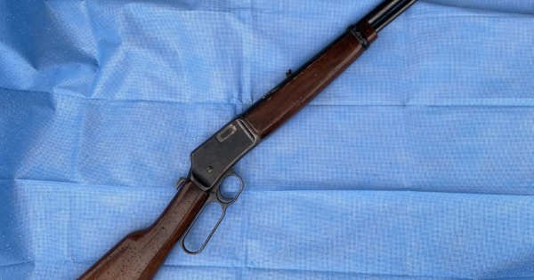 Rifle seized as man charged with 13 offences following Calwell shops arrest