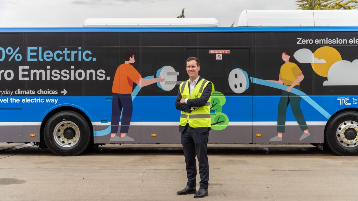 Chris Steel standing by an electric bus