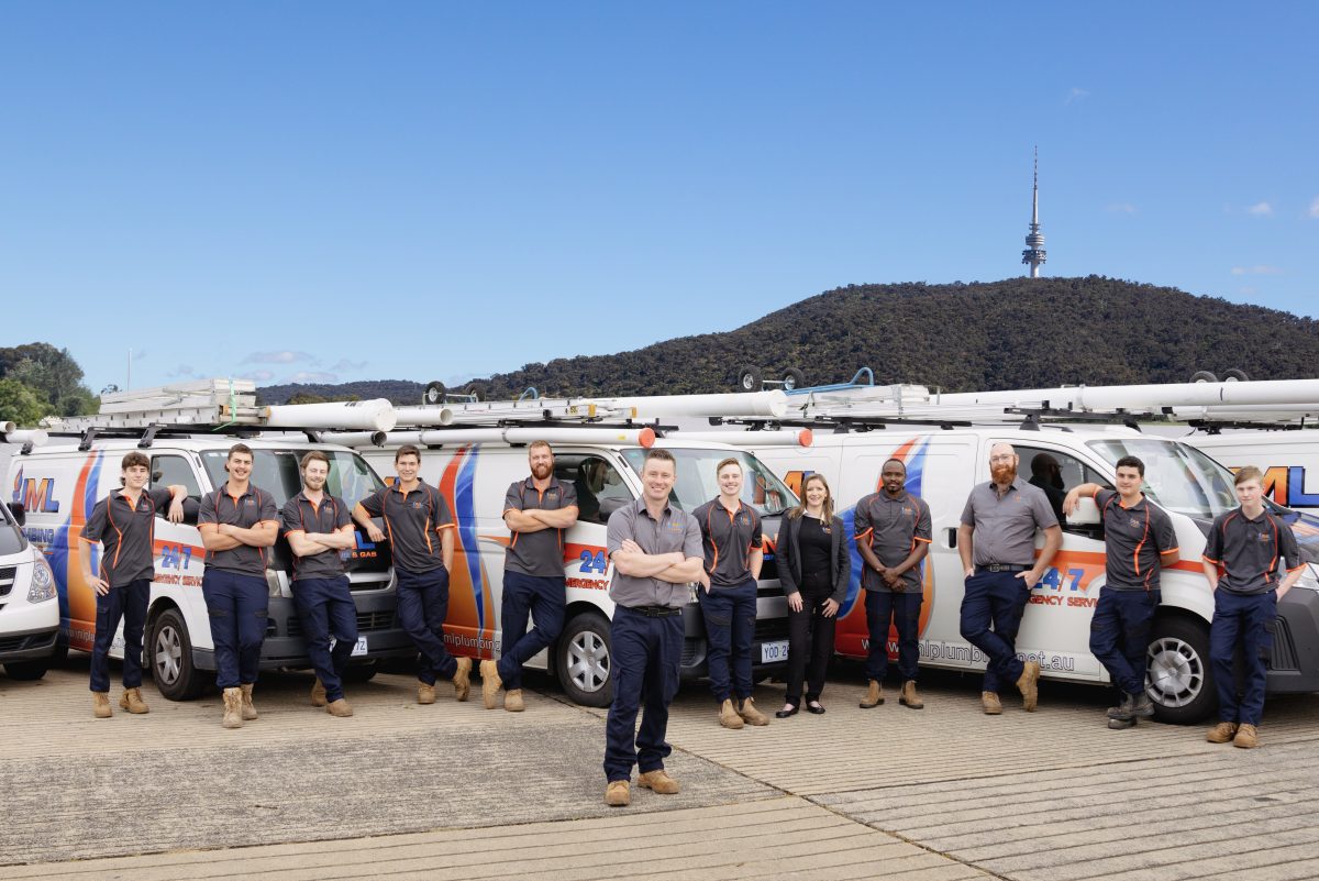 JML Plumbing team standing in front of vans with Telstra Tower in the background