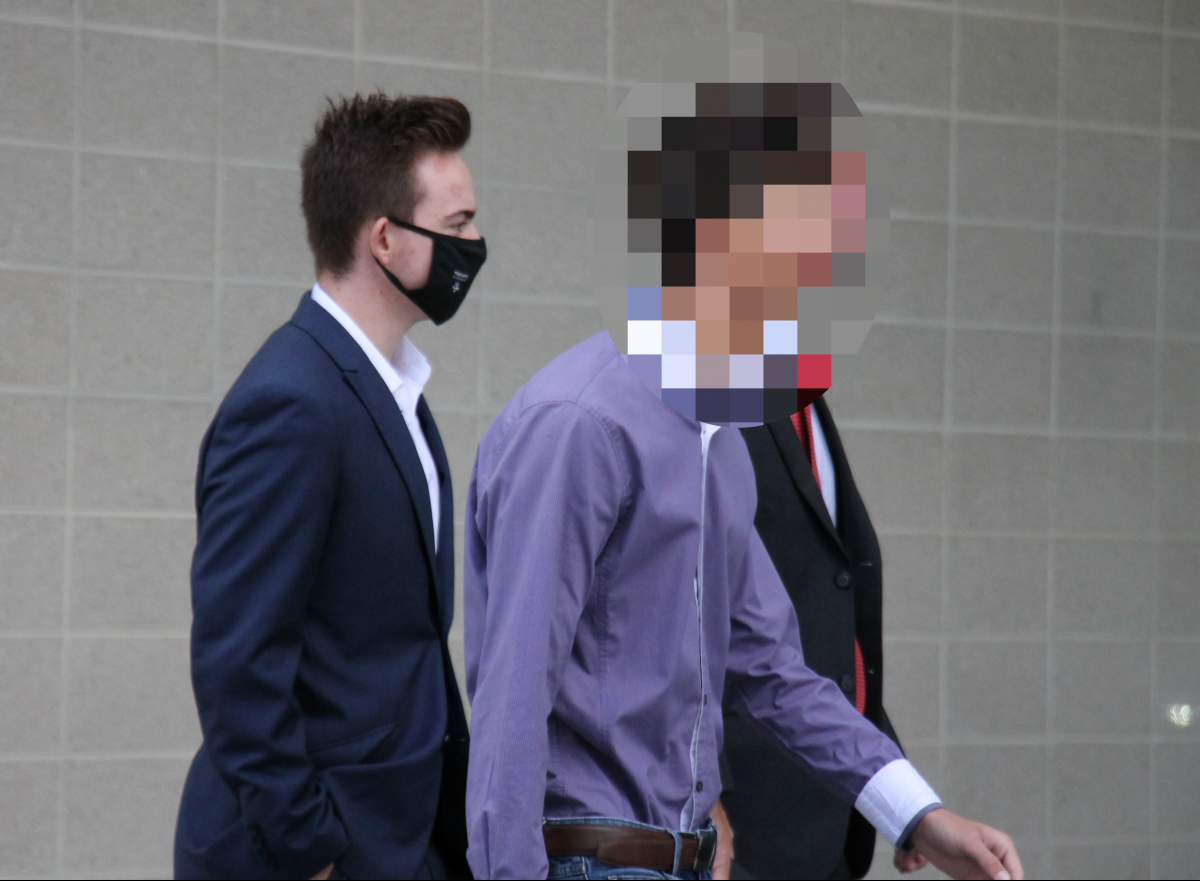 three men walking to court, two faces are pixelated