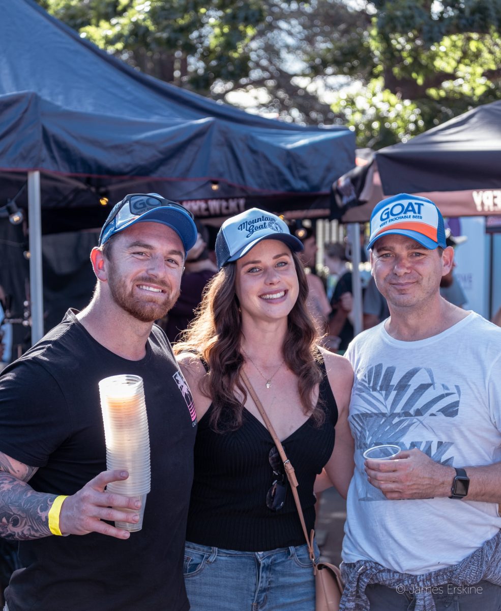 Two men and a woman holding beers