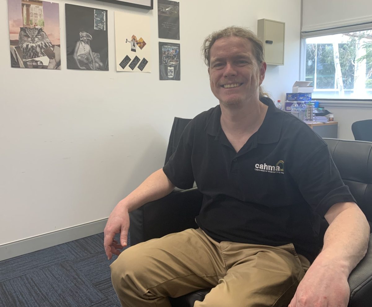 CAHMA CEO Chris Gough smiling while sat on the black sofa chair in his office.