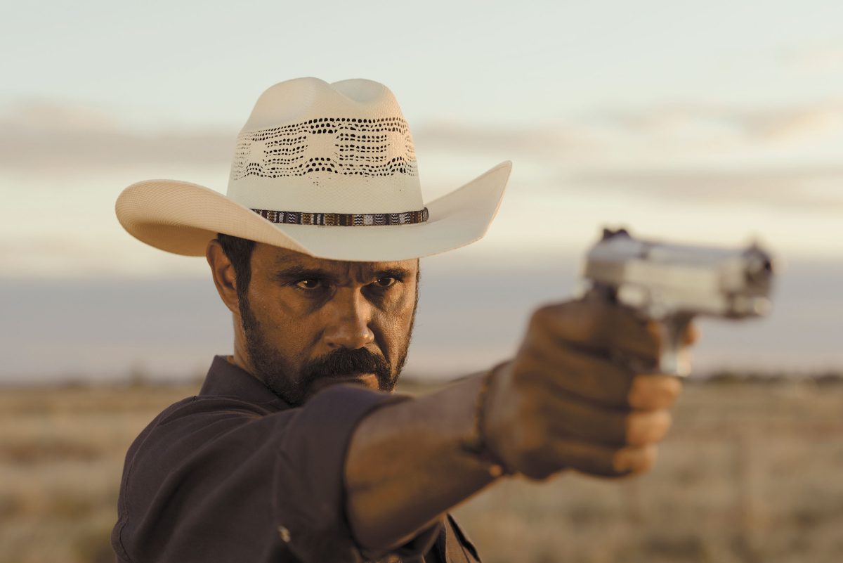 Still from Mystery Road showing a man pointing a gun