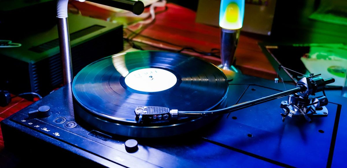 Image of a turntable with a vinyl record, and a lava lamp