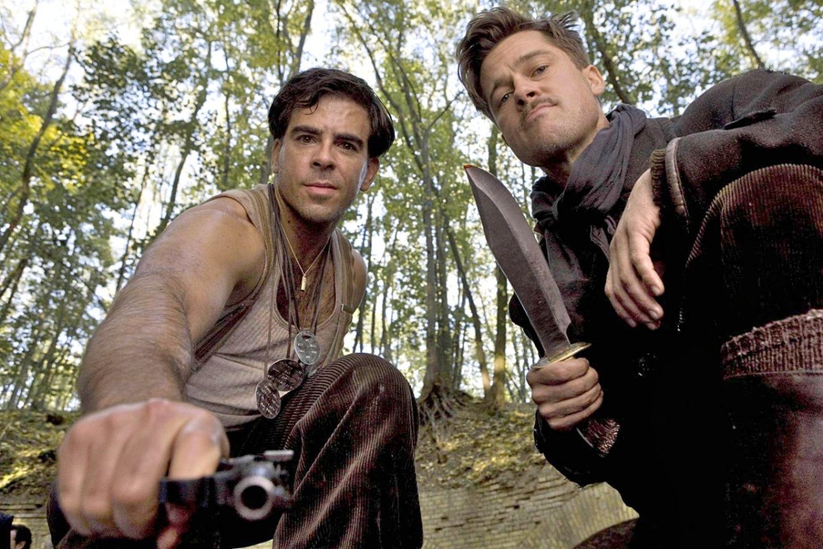 Still from Inglourious Basterds showing two men outside. One is holding a knife and the other is pointing a gun.