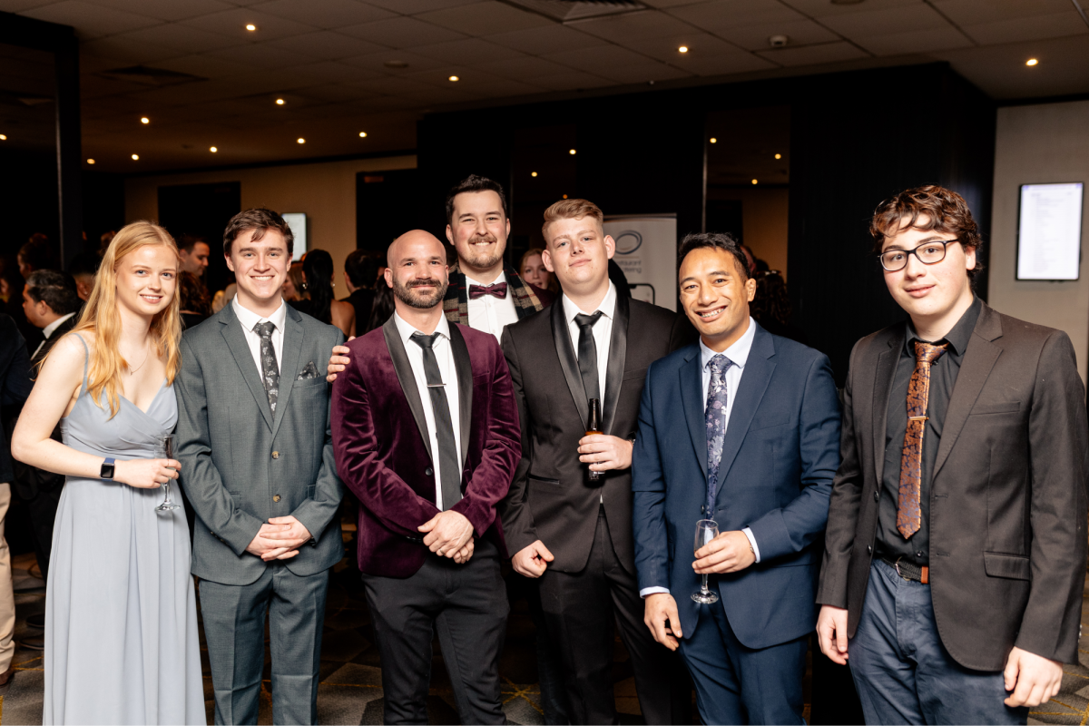 Seven people wearing suits and ties standing in a group