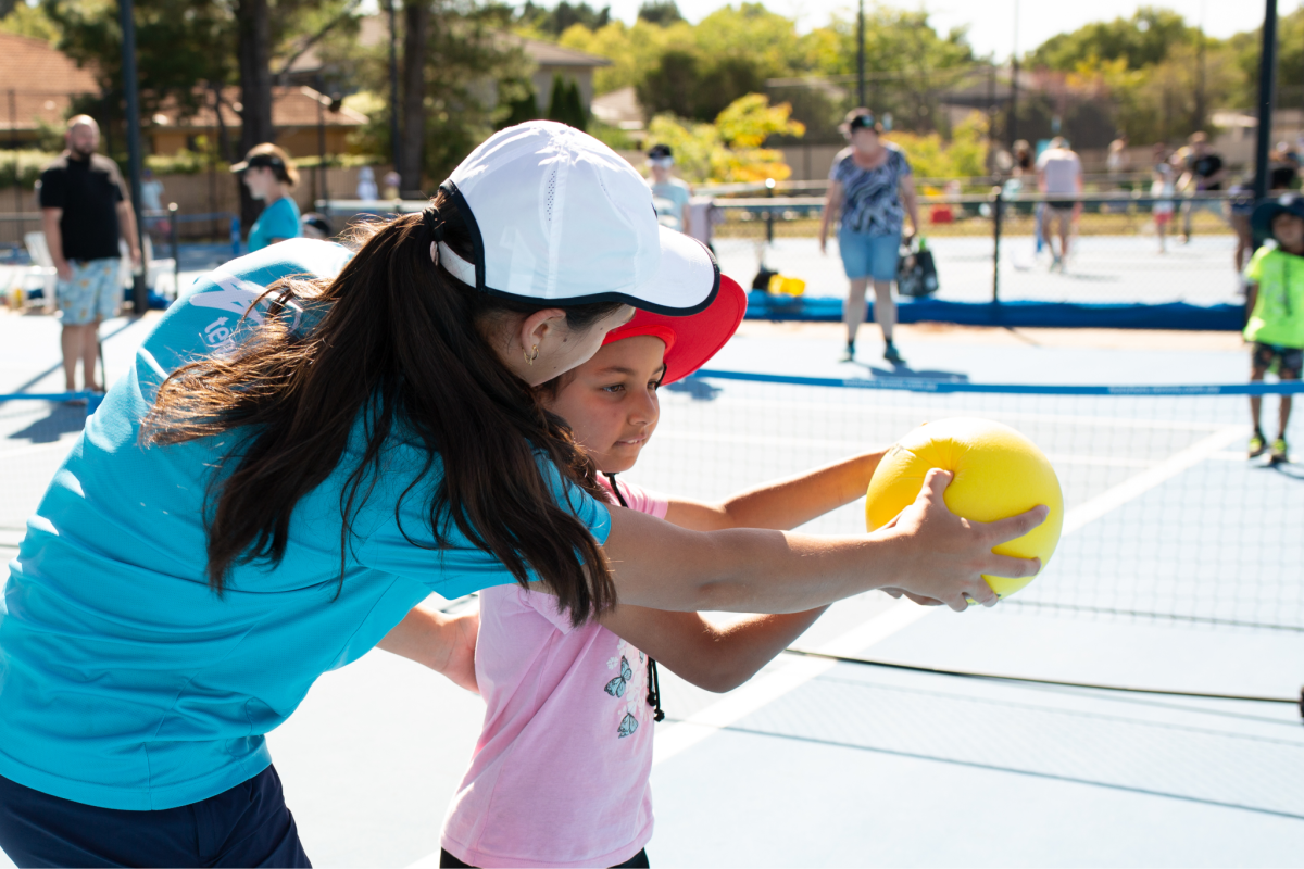 a coach training a child at tennis