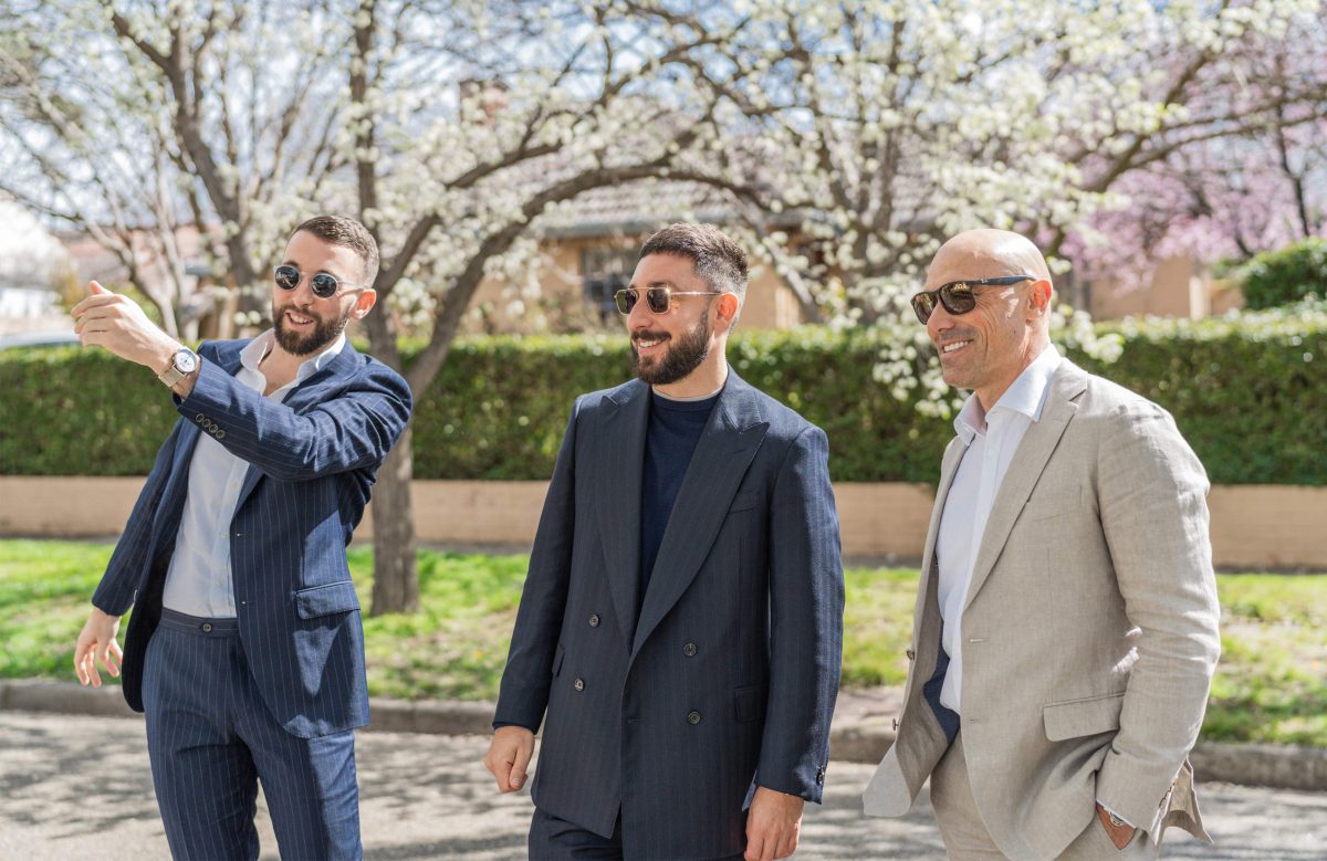 3 men standing outside in suits