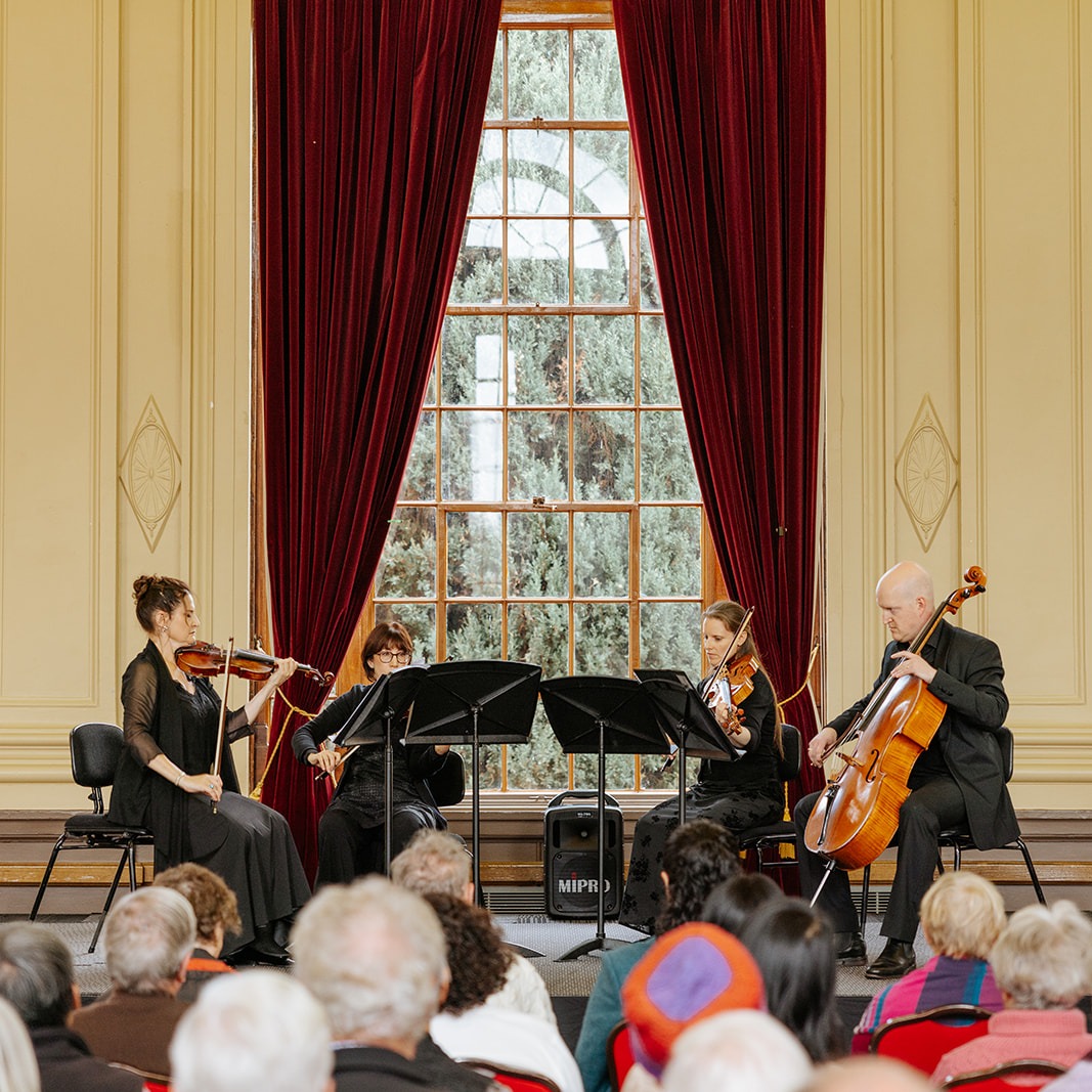 a group of four string musicians playing instruments in Albert Hall