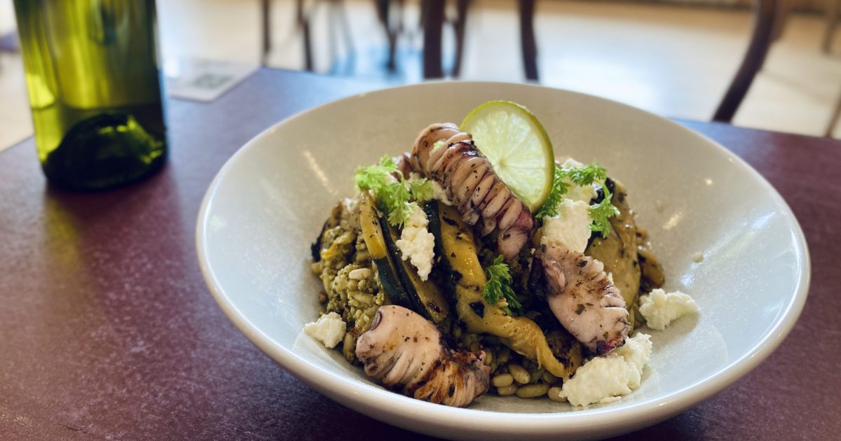 A bowl with calamari and a slice of lime.