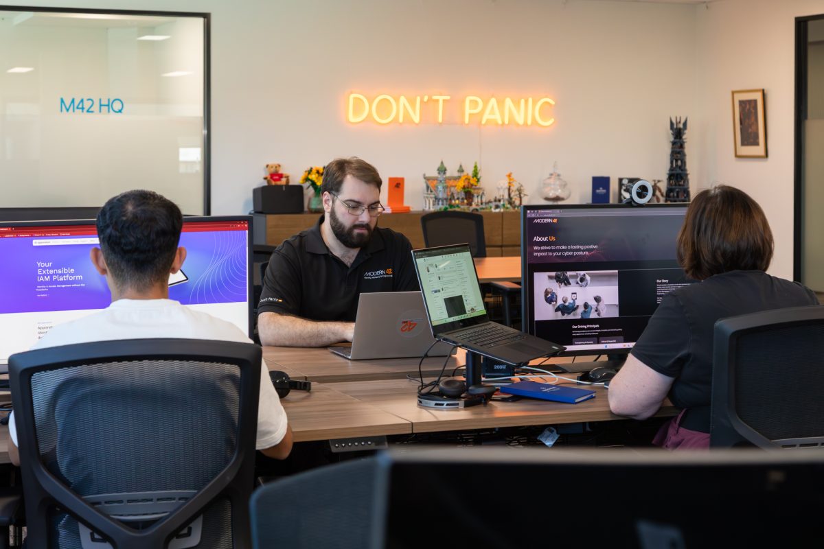 people sitting at desks in front of Don't Panic sign