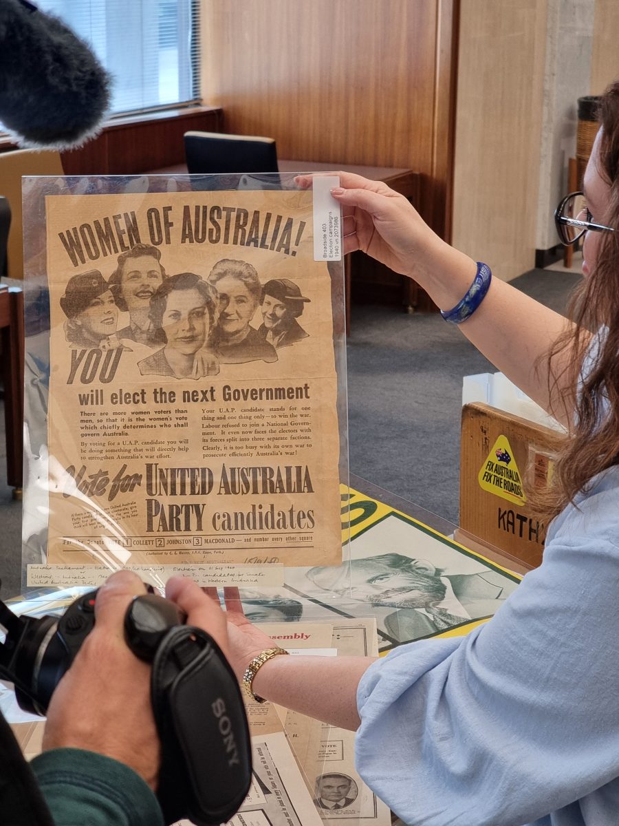 A curator holding a poster in the collection