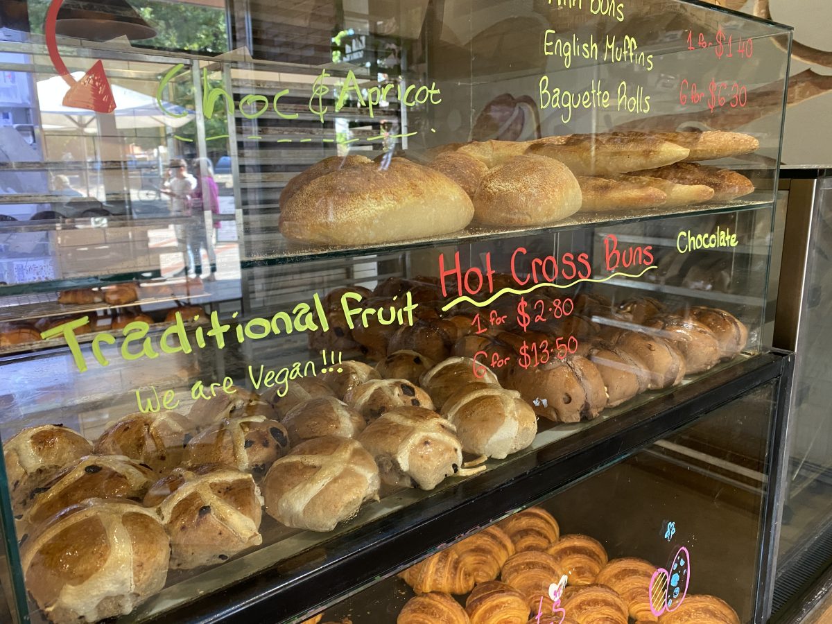 A bakery cabinet with hot cross buns.
