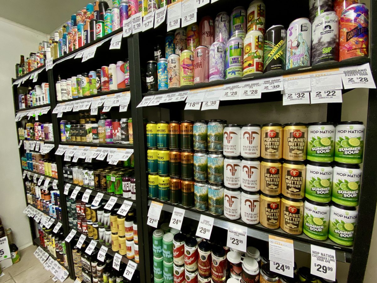 A shelf full of colourful beer cans.