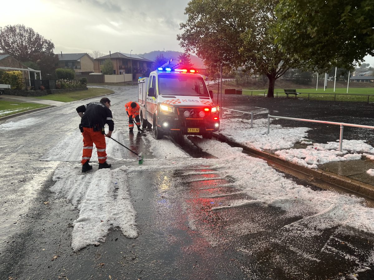 NSW SES volunteers sweeping hail off a road
