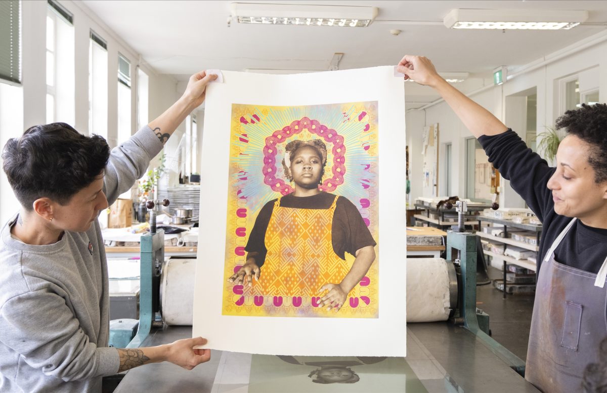 Two women holding up their artwork