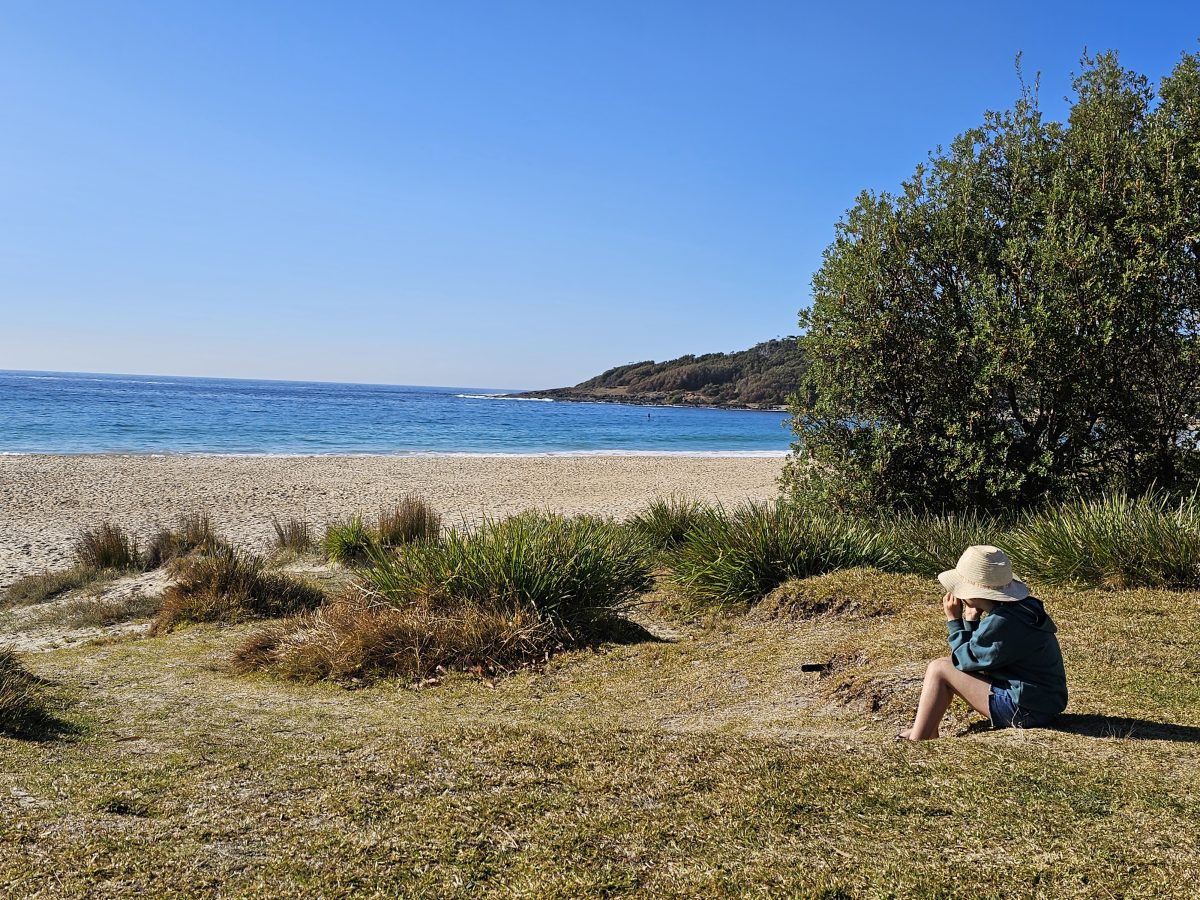 child sitting near a beach