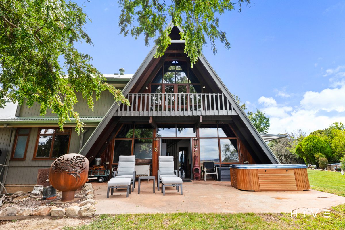 view of A-frame style highlighting spa and balcony