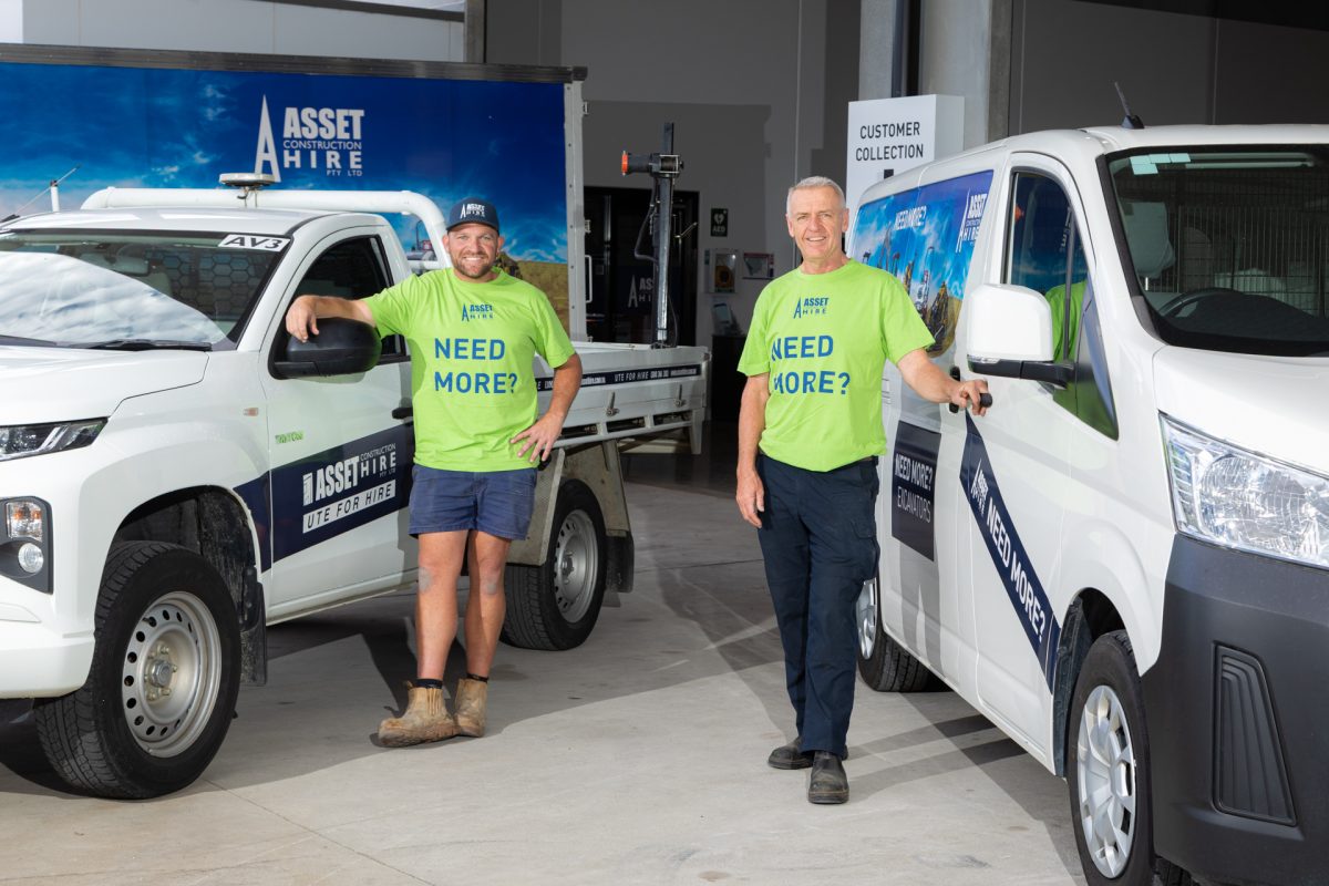 two staff standing near hire vehicles