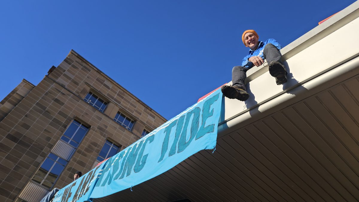 Protestor scales department building