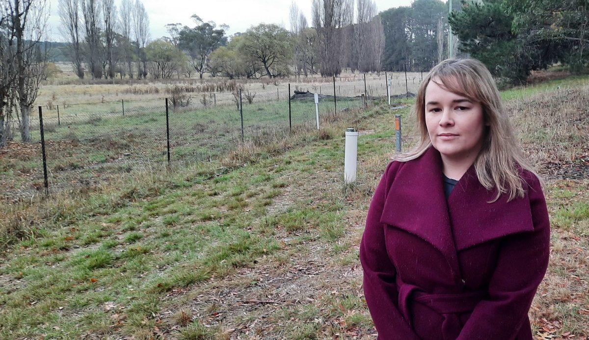 woman standing beside a paddock