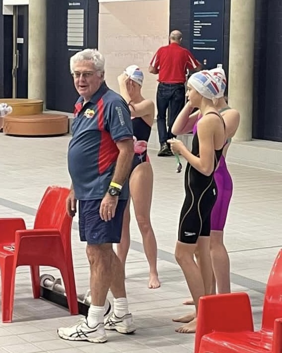 Veteran Telopea coach Les Barclay poolside with Telopea swimmers at the AIS. Photo: Facebook.