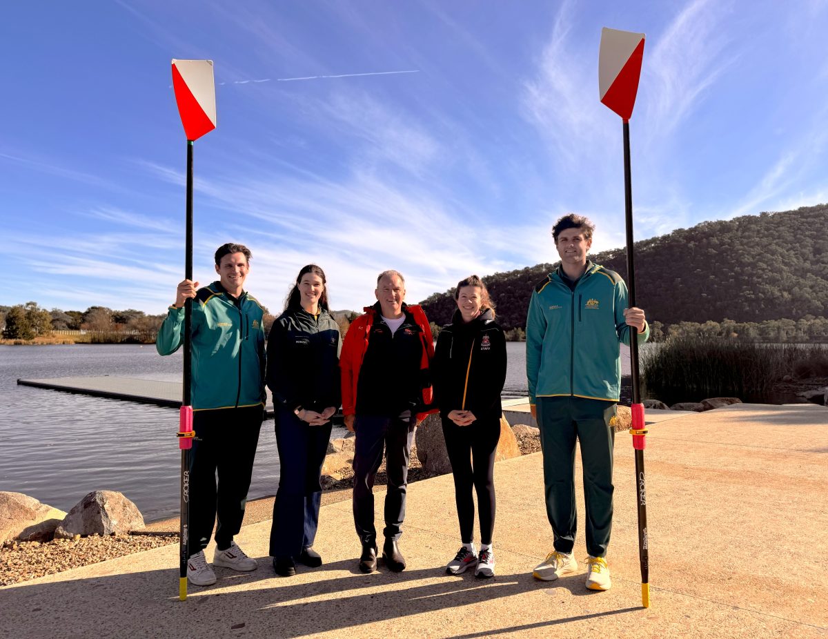 smiling people, with two holding rowing oars