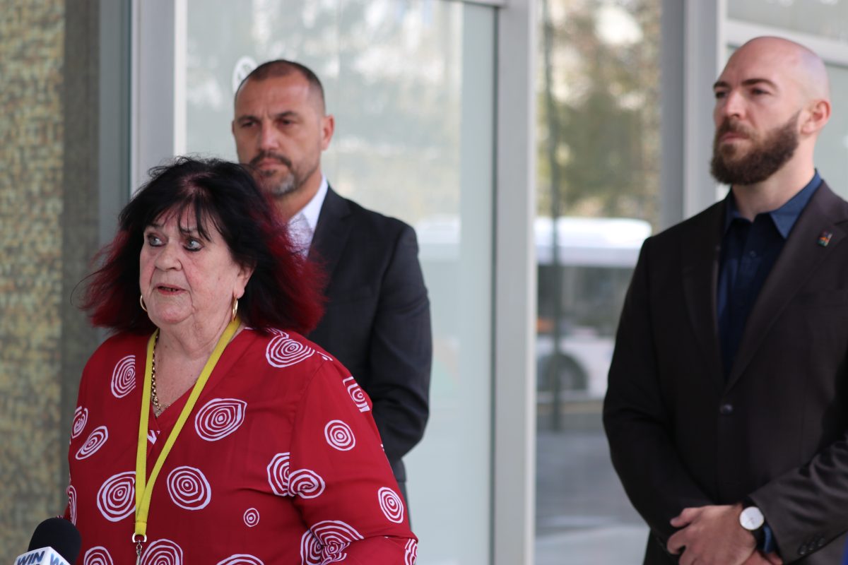 woman and two men outside the legislative assembly