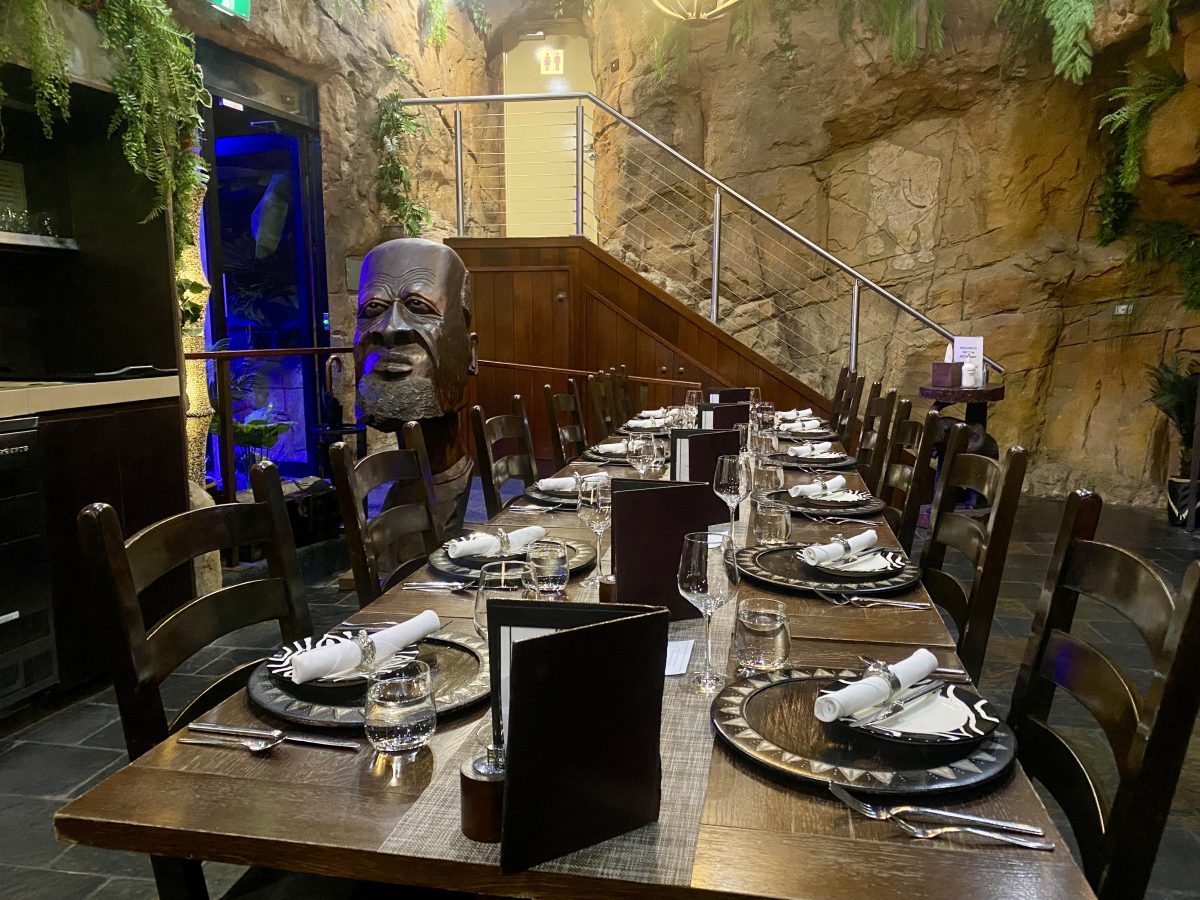 A dining room with African-inspired statues.