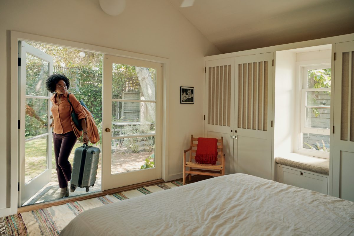 woman with suitcases arriving at AirBnb