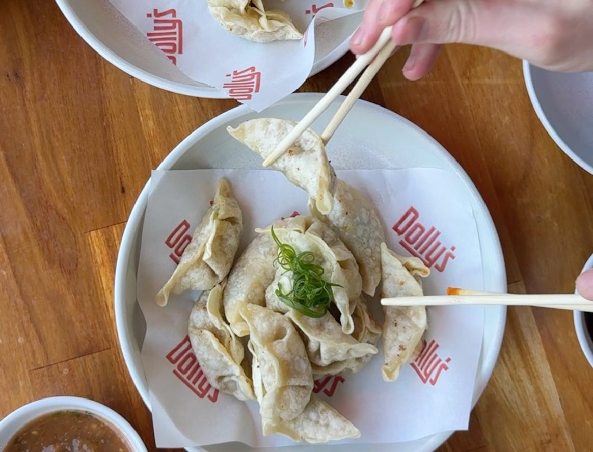 people picking up dumplings with chopsticks