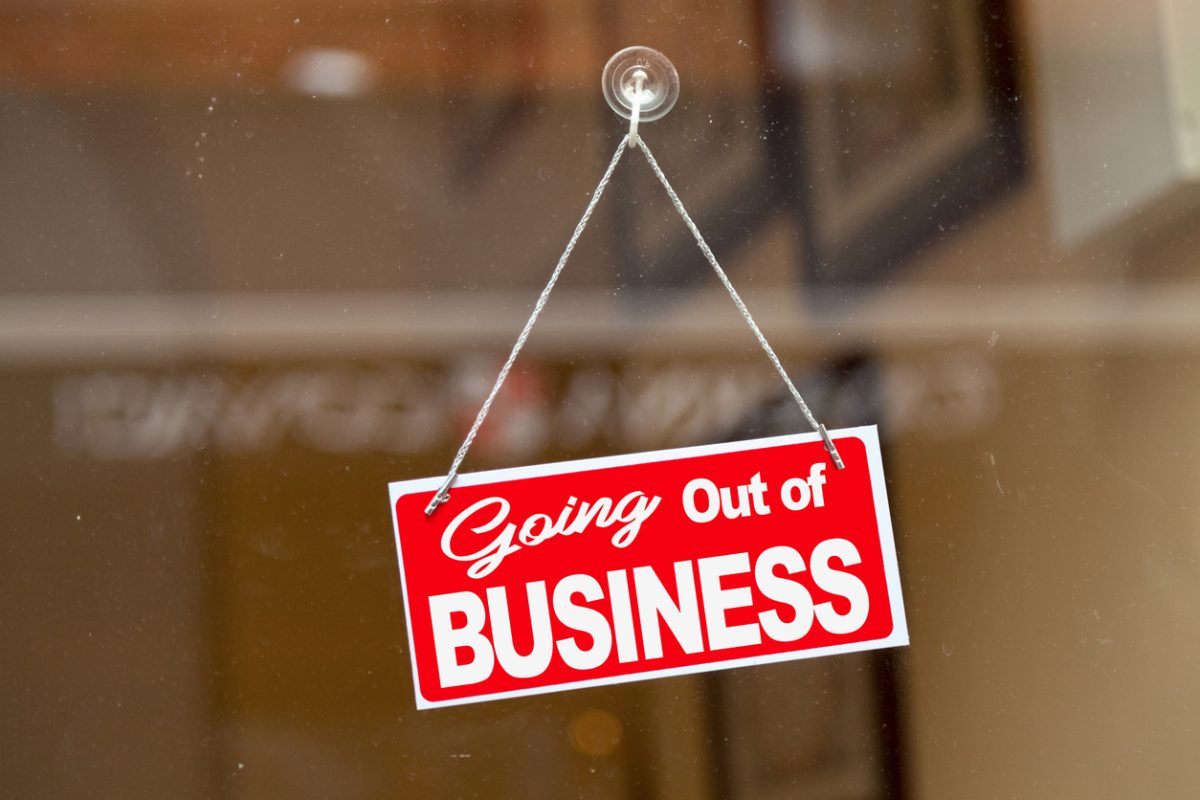 A going out of business sign hangs in a door