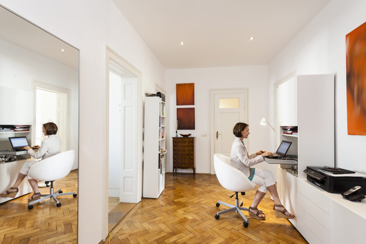 Businesswoman typing on laptop in apartment